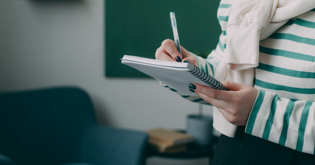 student reviewing notes with planner